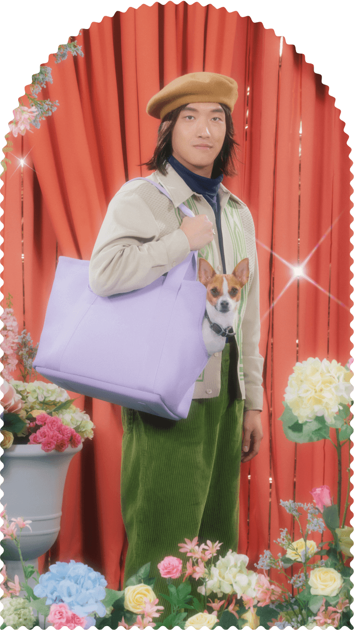 Photo of a young man with a small dog in a handbag.